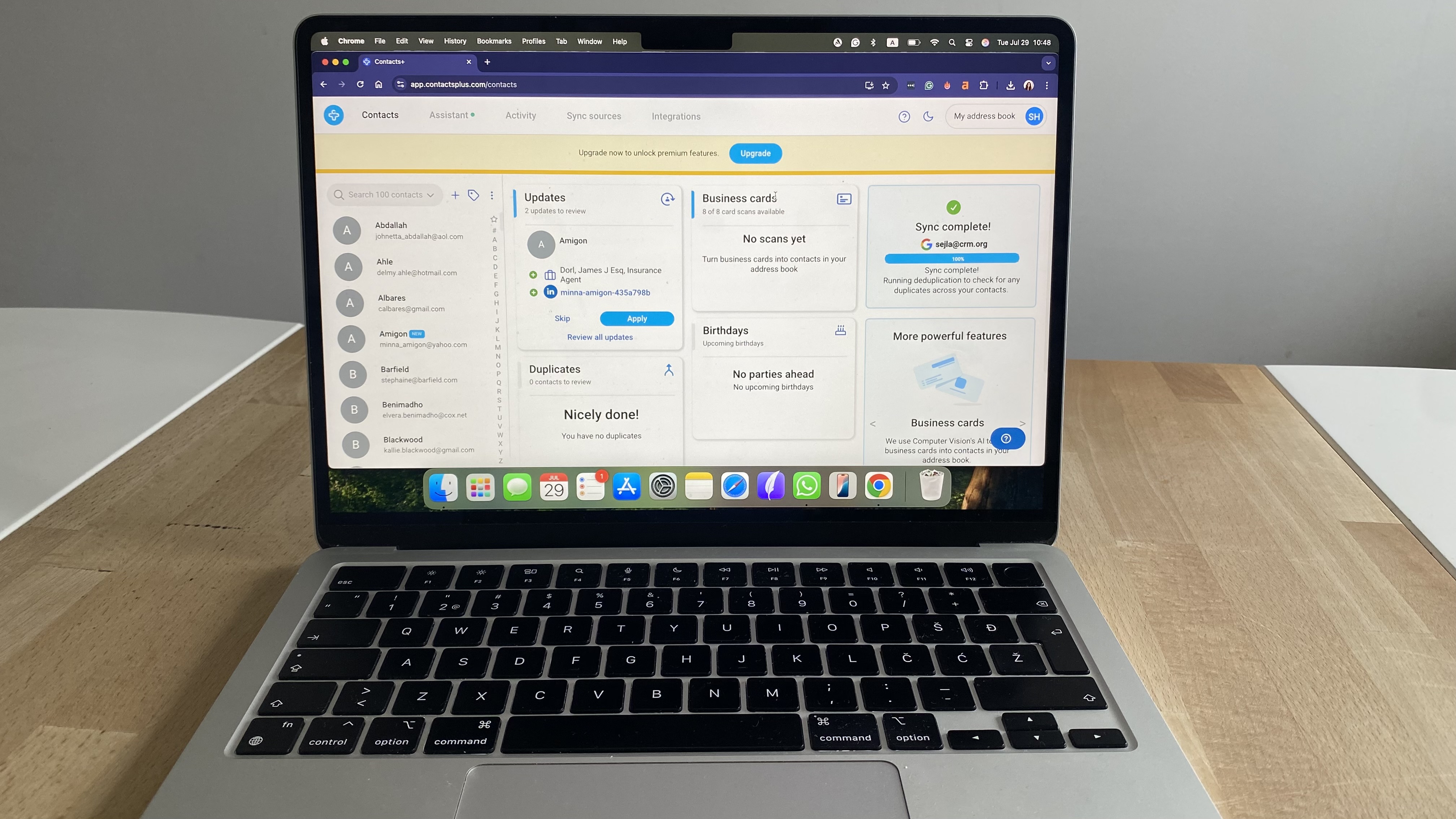 Laptop screen showing Contacts+ dashboard showing contacts list and sync updates