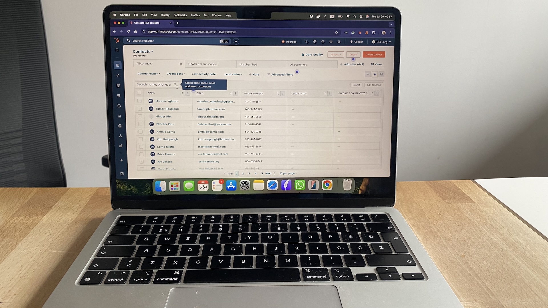 HubSpot CRM contacts dashboard with a searchable list of names, emails, phone numbers, and lead status columns.