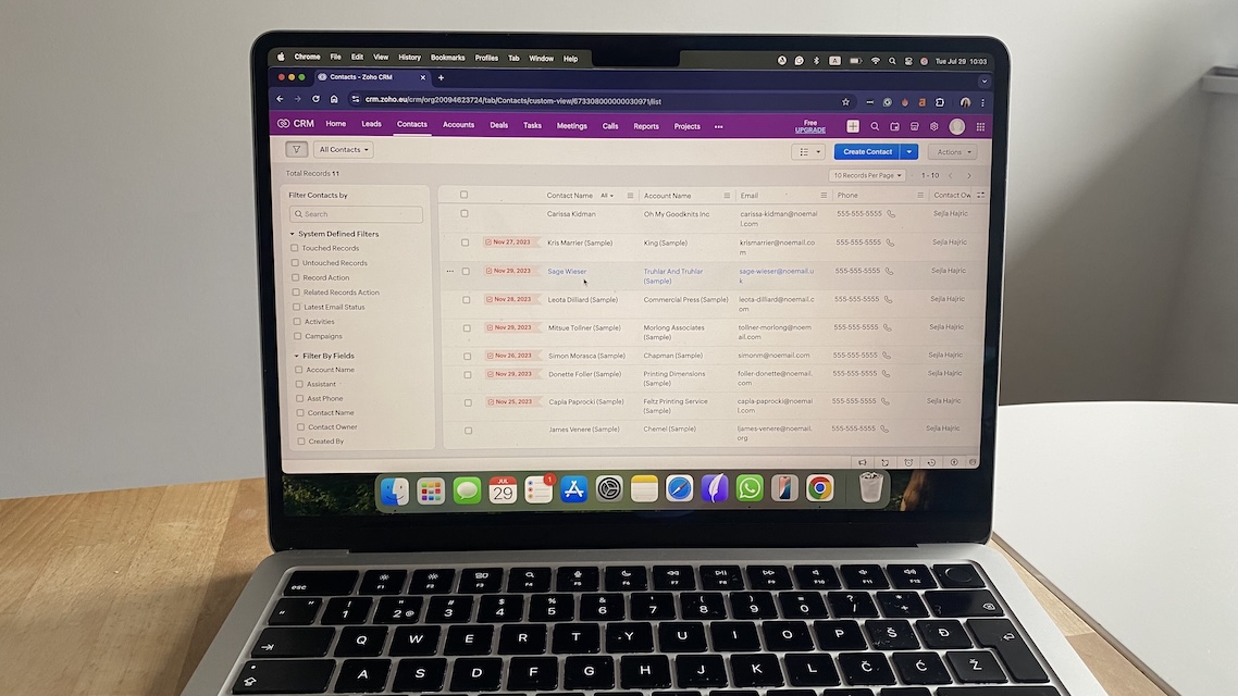 Contact list filtered view in Zoho CRM showing account names, emails, phone numbers, and contact owners.
