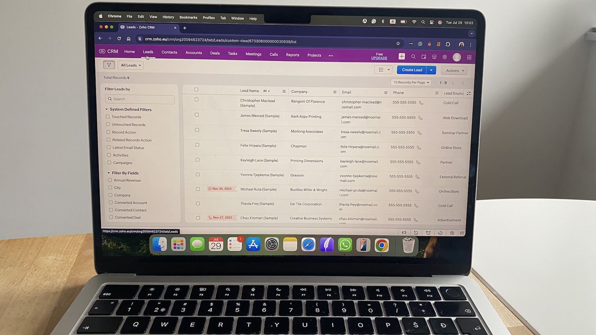 List view of CRM leads in Zoho with fields for name, company, email, phone number, and lead source.
