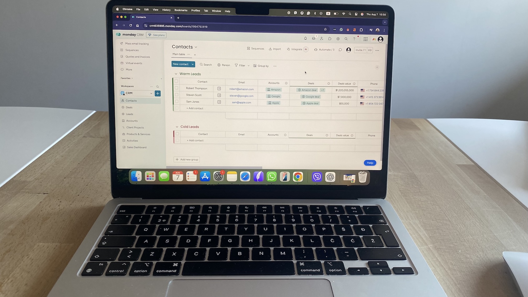 Monday CRM contact list grouped by warm and cold leads, with deal values and linked accounts shown for each entry.